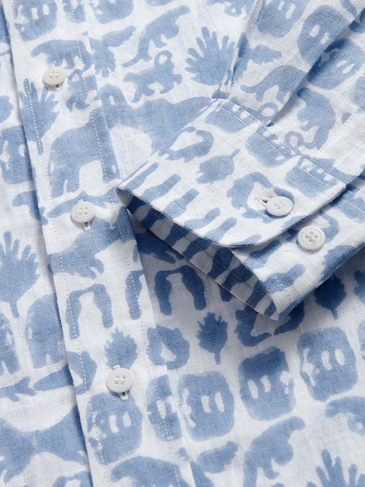 Close-up of unisex linen long sleeve shirt in sky blue, featuring 'Coexist' print with animals of the Indian jungles including elephants, tigers, and hornbills.