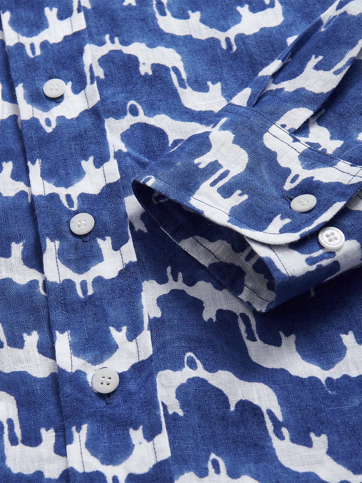 Unisex Linen Long Sleeve Shirt in Elephant Palace Blue with a detailed close-up of its premium Belgian linen fabric and traditional block print featuring white elephant designs.