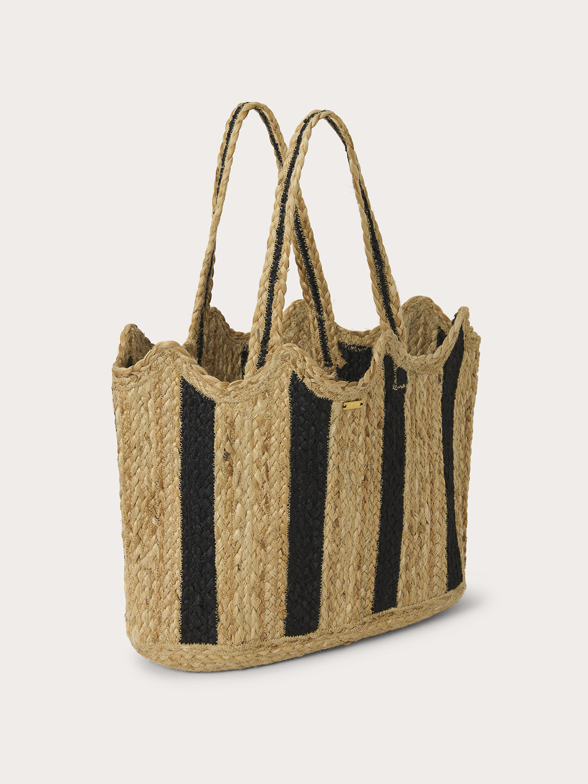 A woven straw tote bag with vertical black stripes and two long shoulder straps, photographed on a clean light grey background.