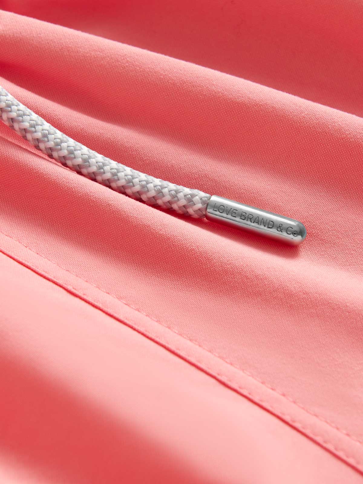 Close-up view of pink/red kids swimming trunks fabric.