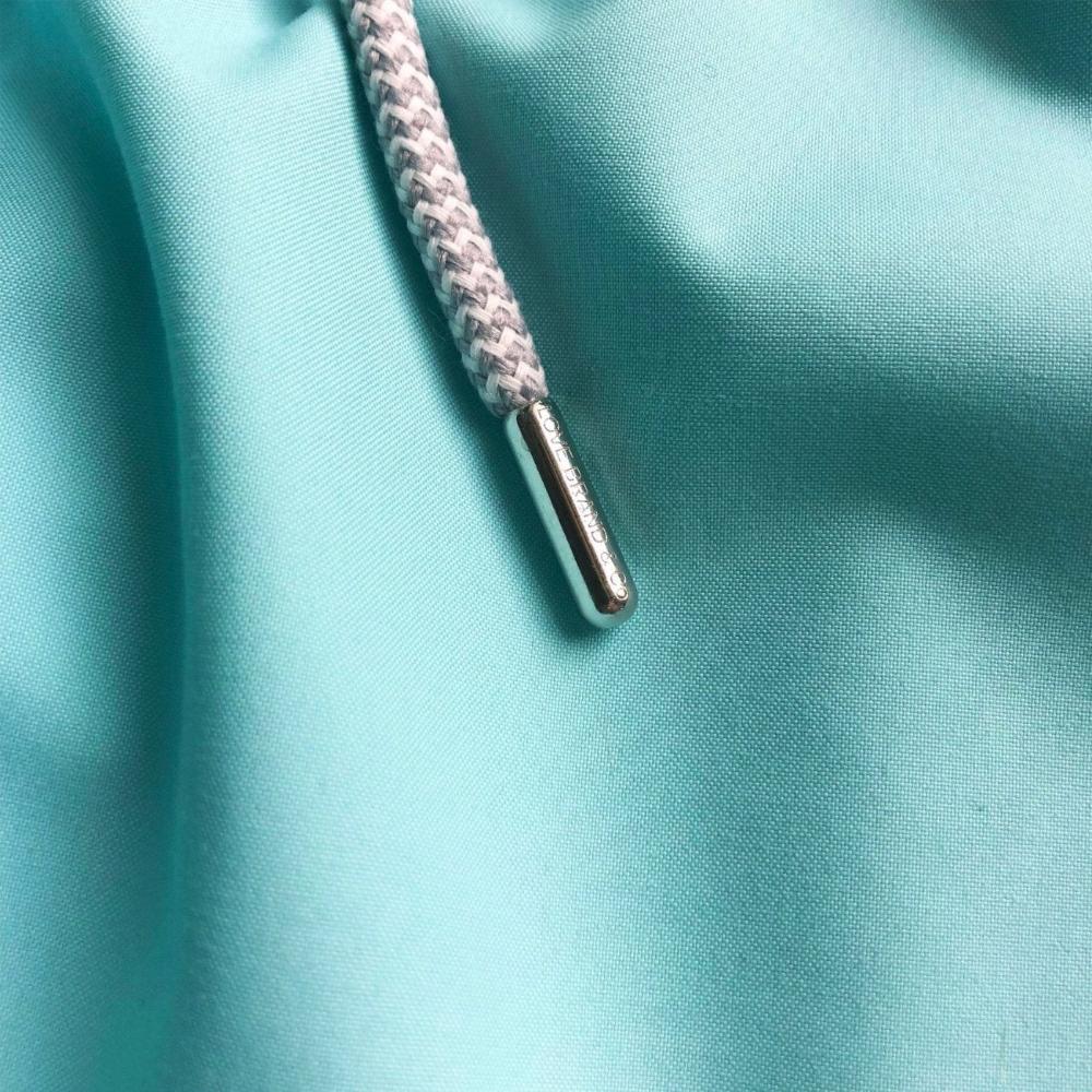 Close-up view of fabric on Boys Cay Green Staniel Swim Shorts. Boys green swim shorts in a mint green colour.