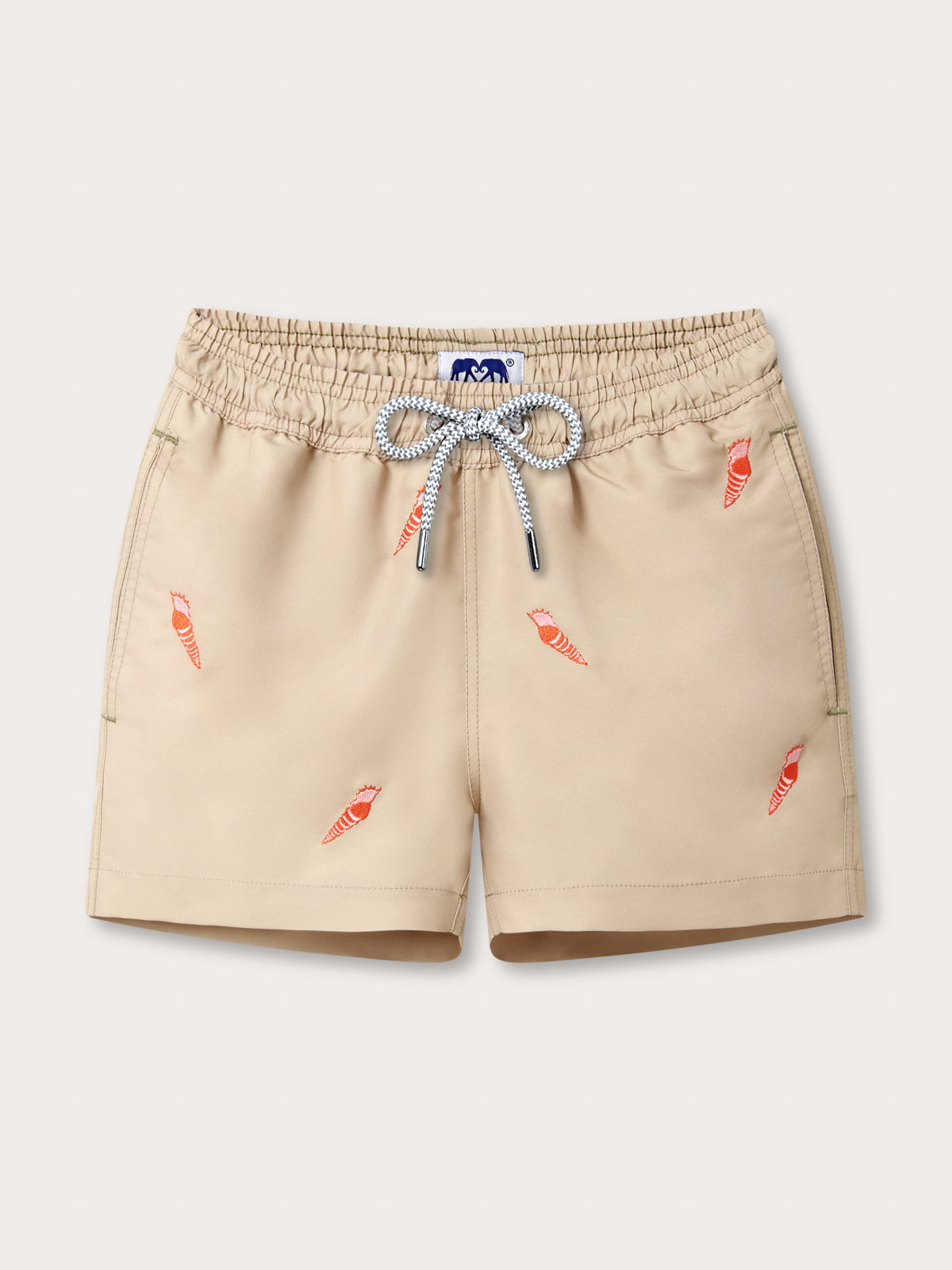 Front view of Boys Shellebration Staniel Swim Shorts. Beige swim trunks for boys with embroidered red conch shells.