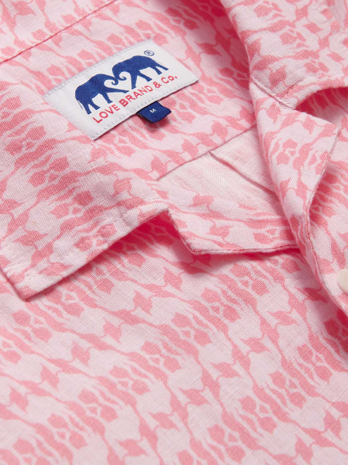 Close-up of the Men's Camel Mirage Pink Arawak Linen Shirt featuring a pink and white mirage-like pattern. Men's linen shirt with the Love Brand & Co. logo on the collar.