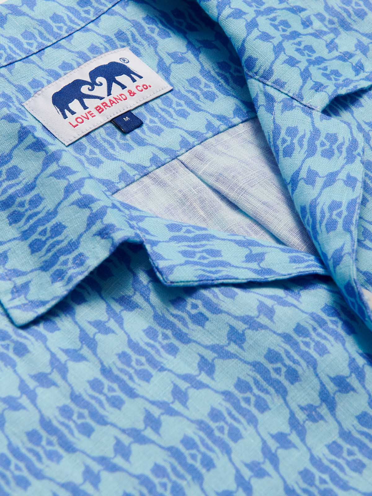 Close-up of the Men's Camel Mirage Sky Arawak Linen Shirt, showcasing its unique blue pattern and the Love Brand & Co. label.