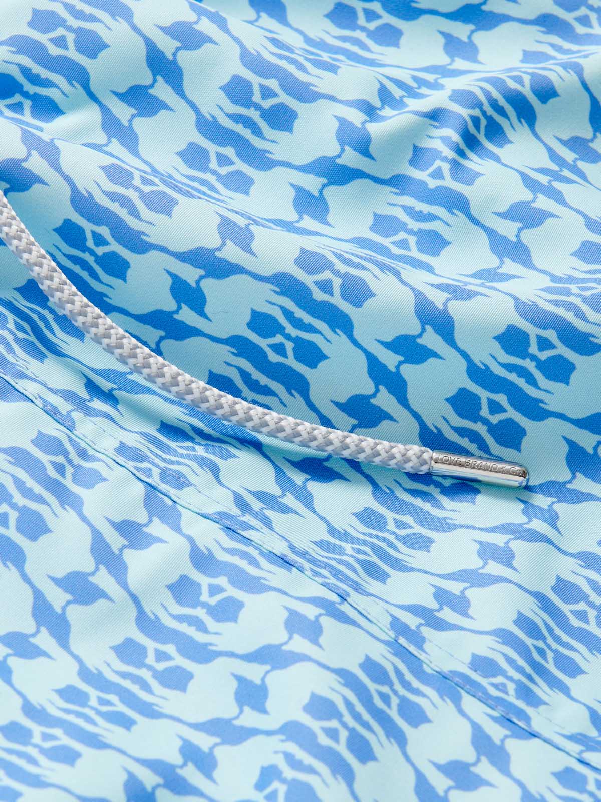 Camel Mirage Sky Staniel Mens Swim Shorts detail. This design features light blue camels on a dark blue background.