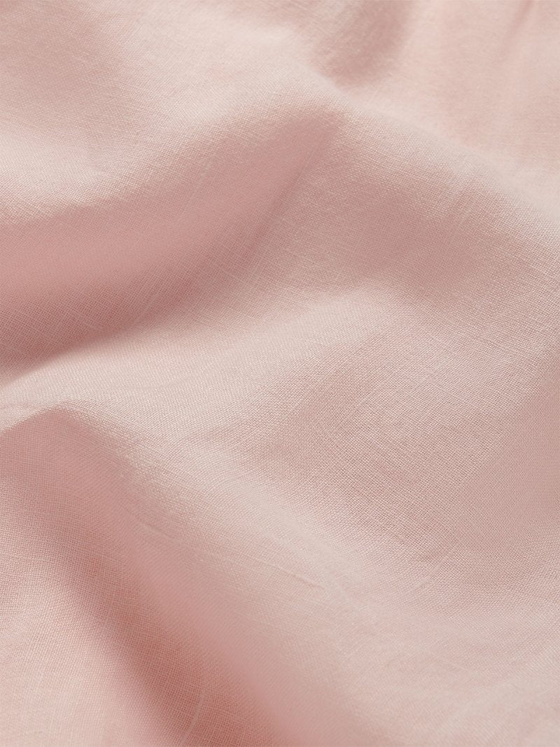 Close-up view of pastel pink linen fabric for Men's Eleuthera Trousers. Pink linen clothing for men.