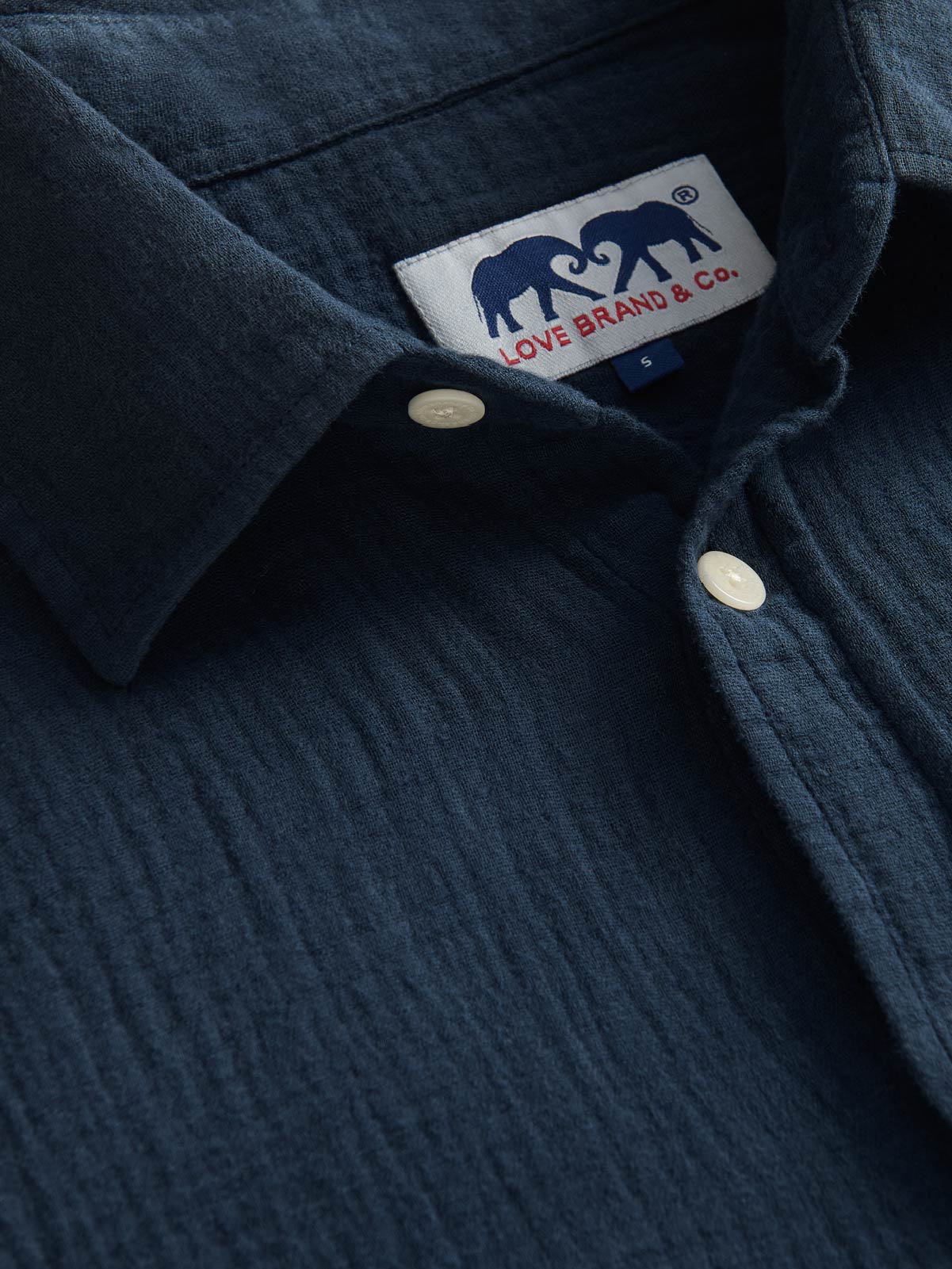 Navy blue shirt with a visible brand label on the collar.