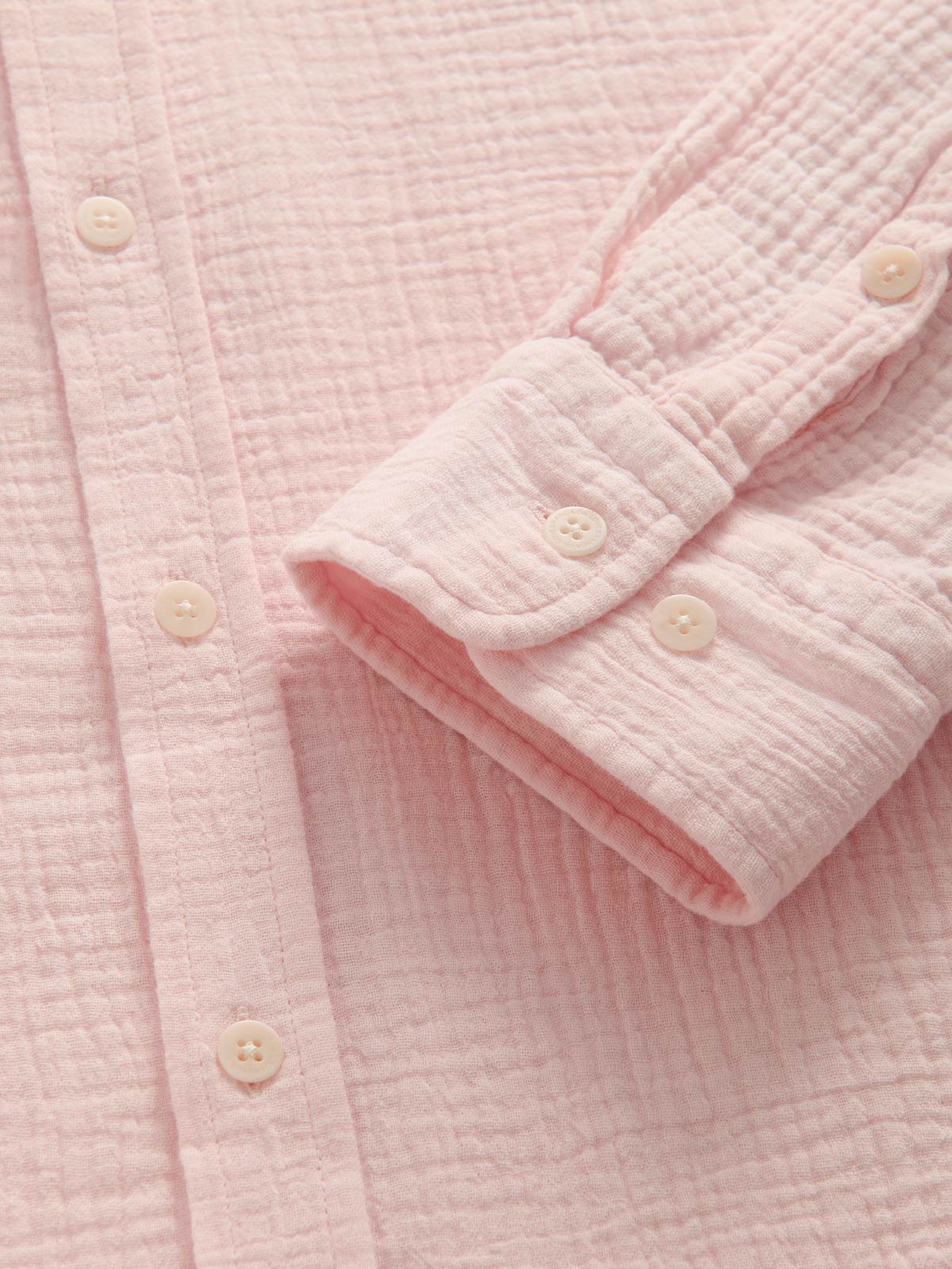 Close-up of a pink textured shirt with buttons