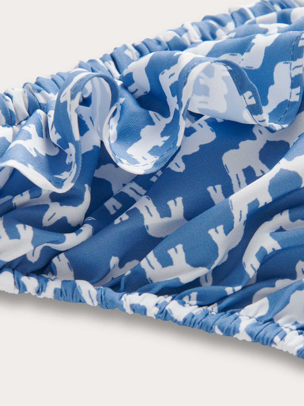 Close-up fabric view of Girls Elephant Palace Blue Calabash Bikini Bottoms. Elephant palace blue print showing elephants and Indian palaces.