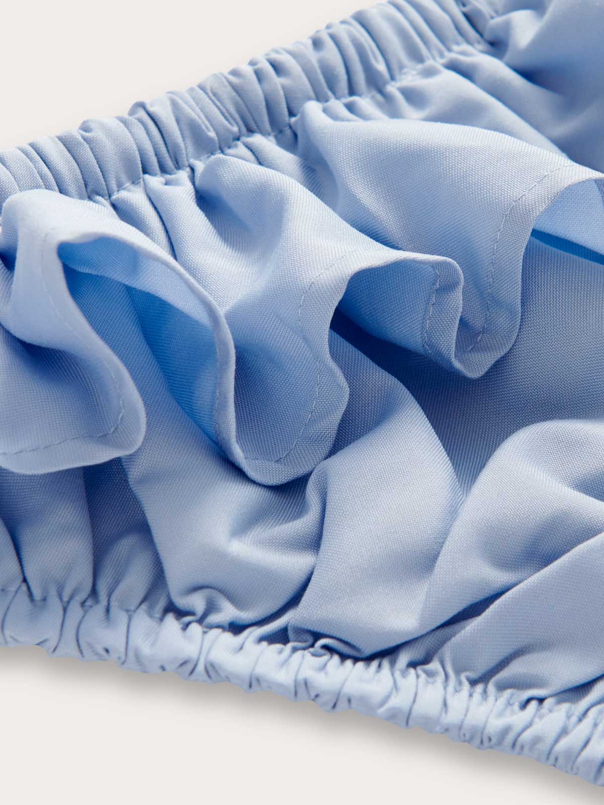 Close-up view of Girls Sky Blue Calabash Bikini Bottoms. Recycled blue fabric details.