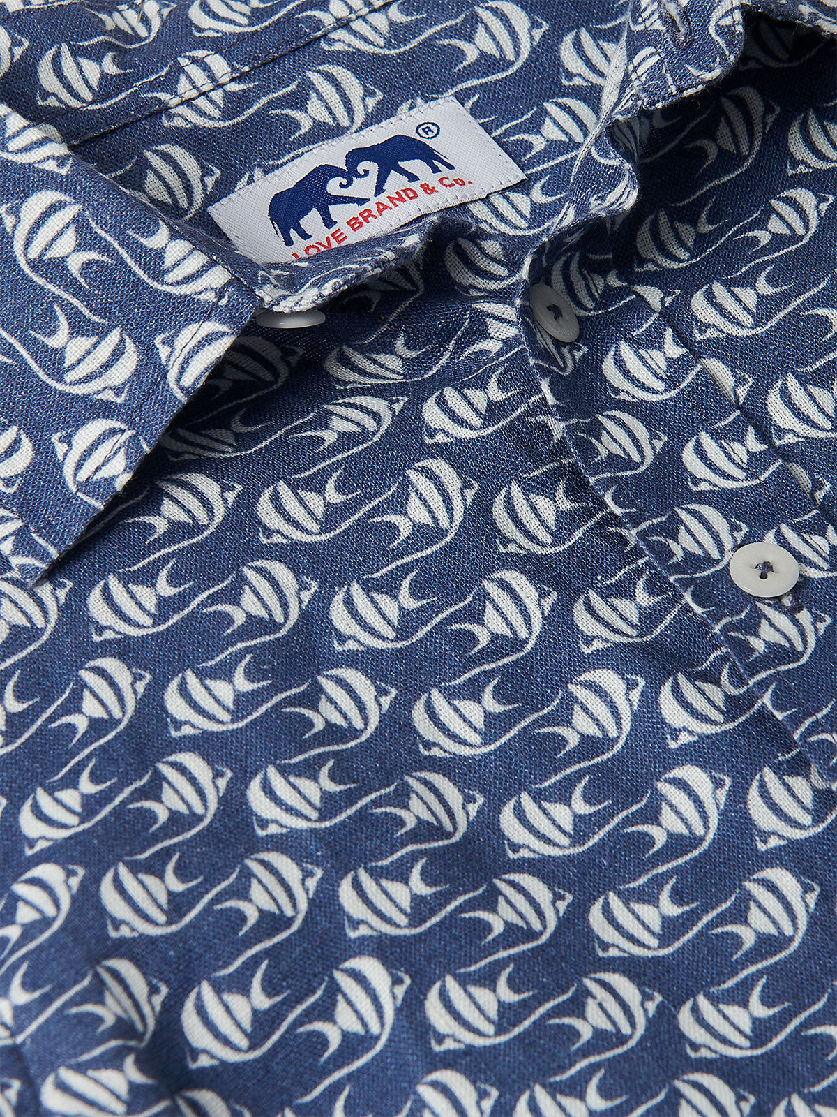 Close-up view of the Boys Go With the Flow Abaco Linen Shirt, featuring a pattern of Moorish Idol fish on a deep blue background.