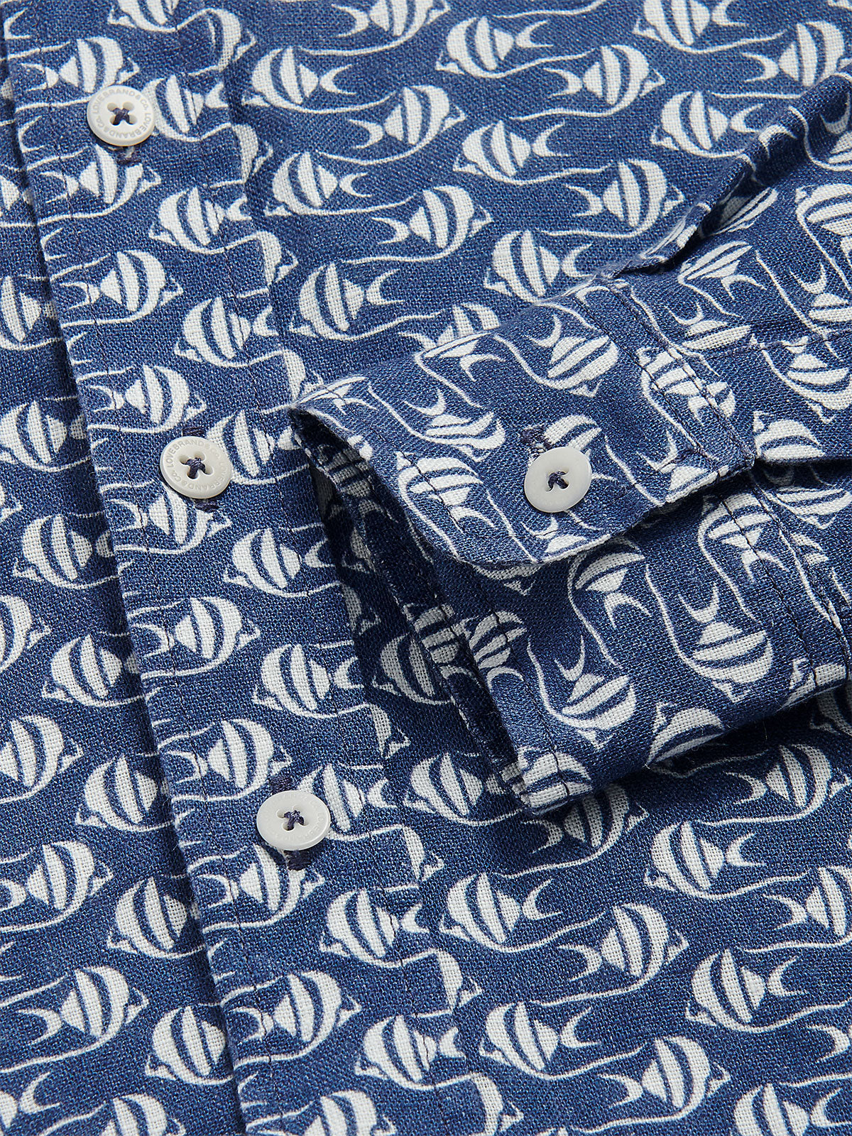 Close-up view of the Boys Go With the Flow Abaco Linen Shirt, featuring a Moorish Idol fish print on a deep blue background with visible white buttons and detailing.