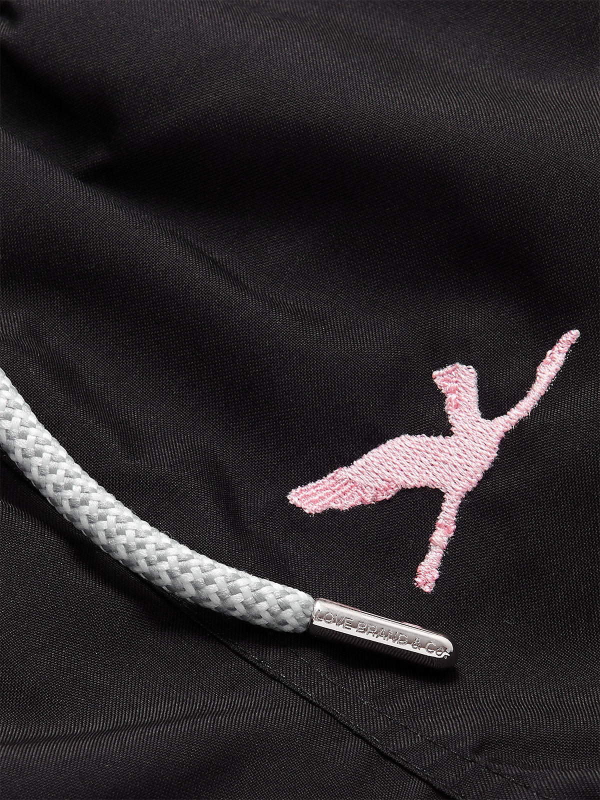 Close-up view of the Boys Lake Nakuru Staniel Swim Shorts, featuring a pink embroidered flamingo and a grey drawstring with metallic tips.