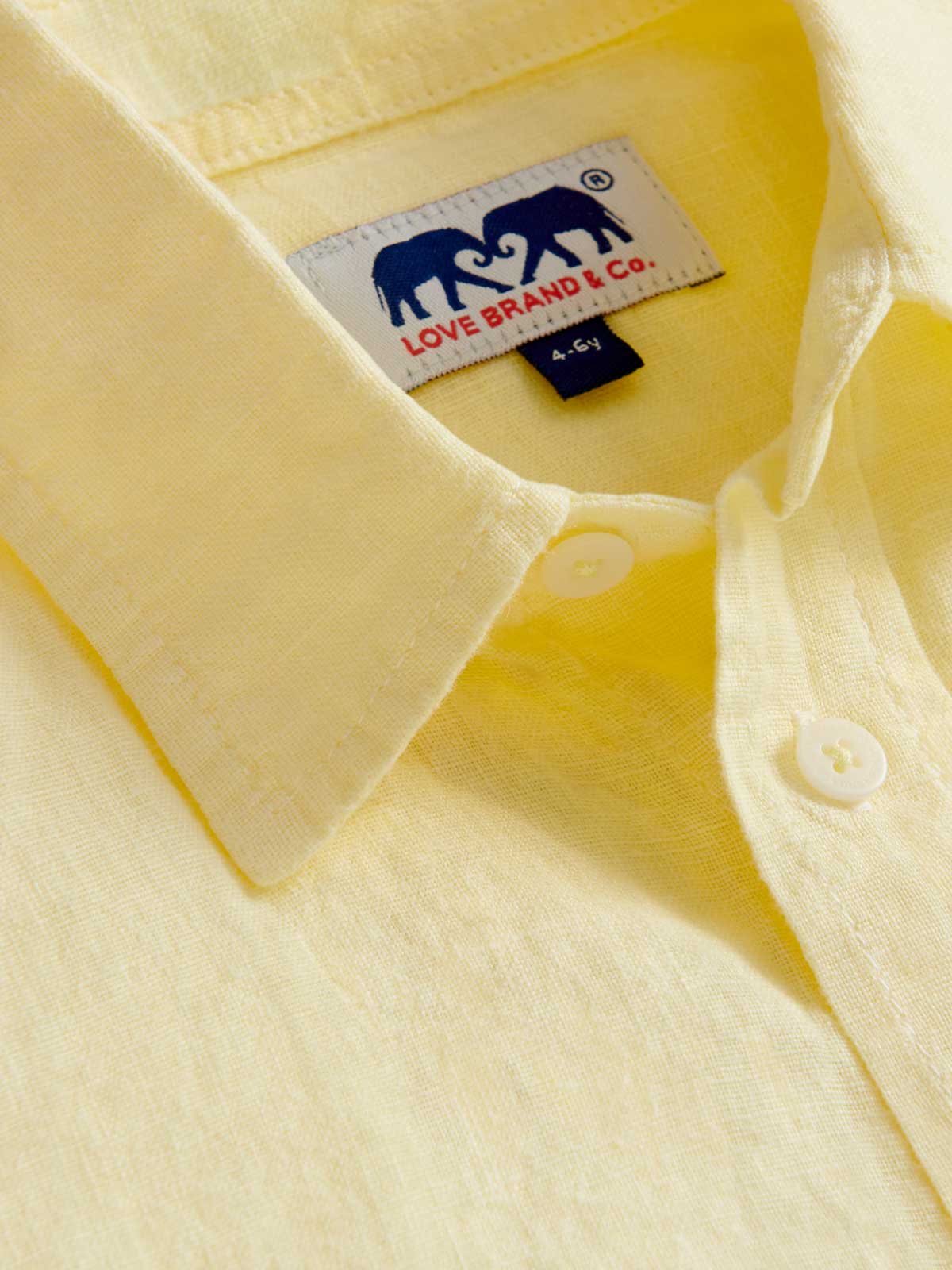 Close-up view of Kids Limoncello Abaco Linen Shirt showing yellow linen fabric and love brand label.