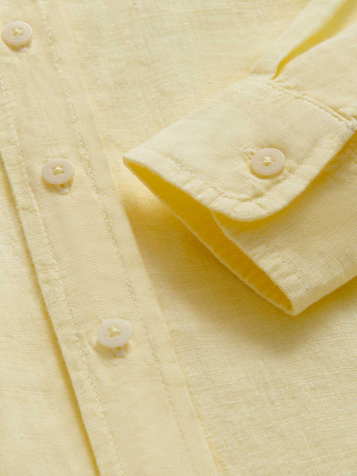 Close-up view of the cuff of Kids Limoncello Abaco Linen Shirt. Yellow linen fabric and corozo nut buttons.