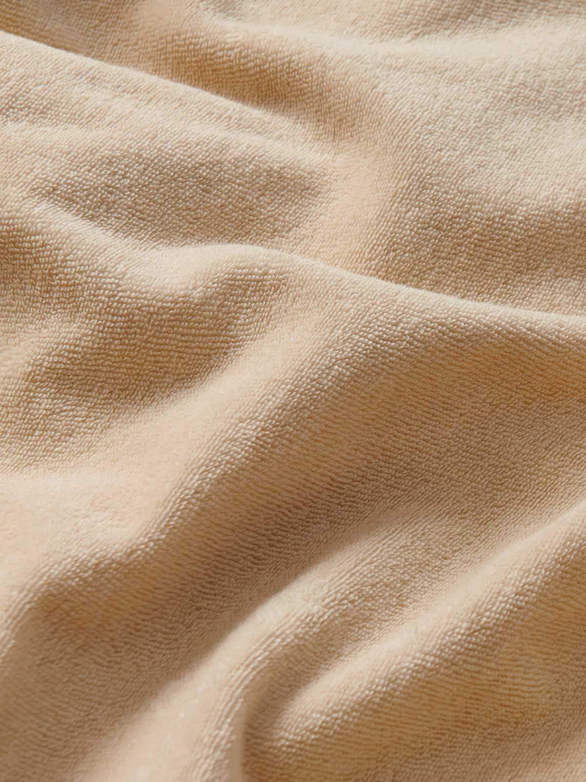 Close-up view of Kids Coconut Holmes Terry Shorts. Beige shorts for children.