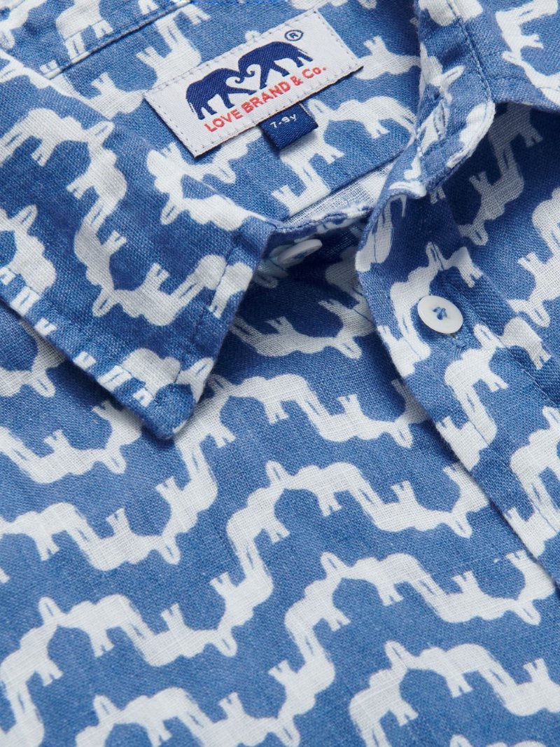 Close-up view of Kids Elephant Palace Blue Abaco Linen Shirt. Showcasing blue and white elephant design.