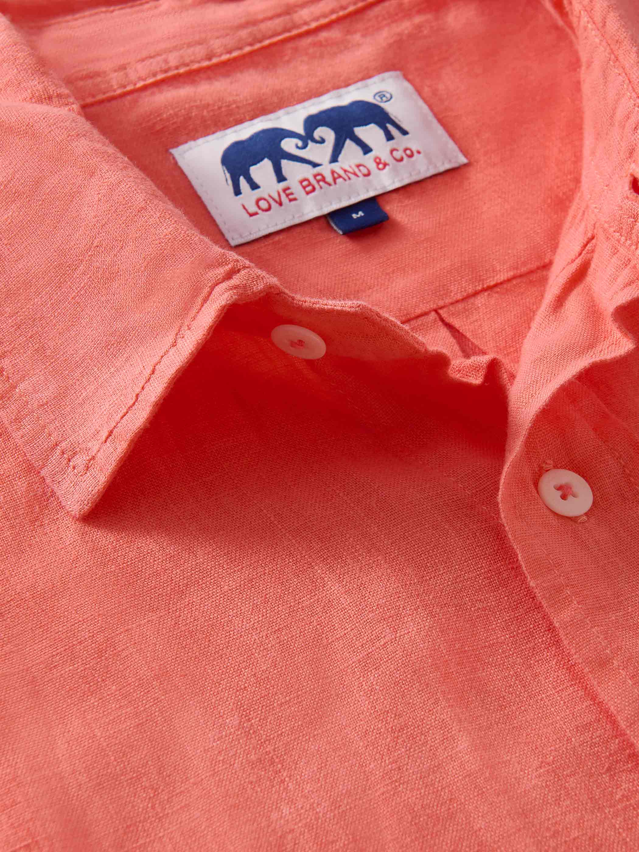 close up view of collar of mens coral shirt