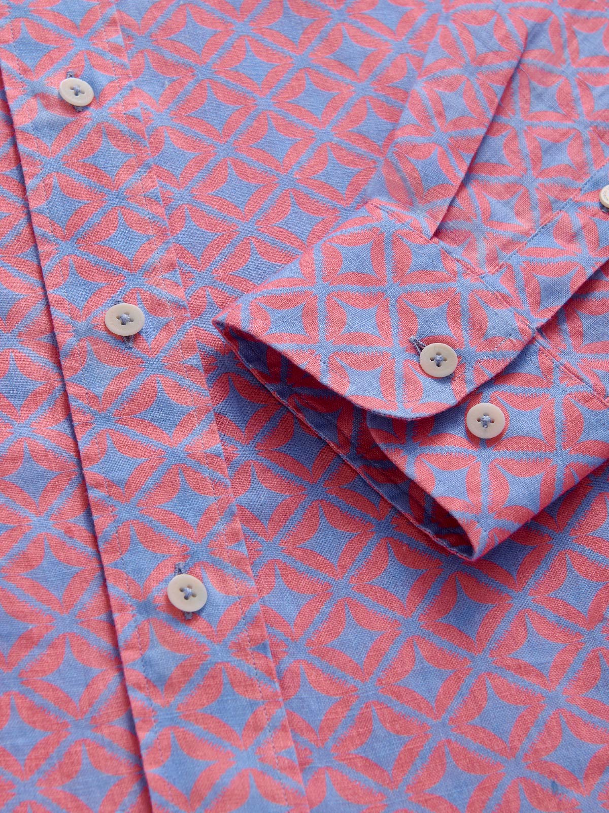 Close-up of a pink and blue patterned shirt with buttons.
