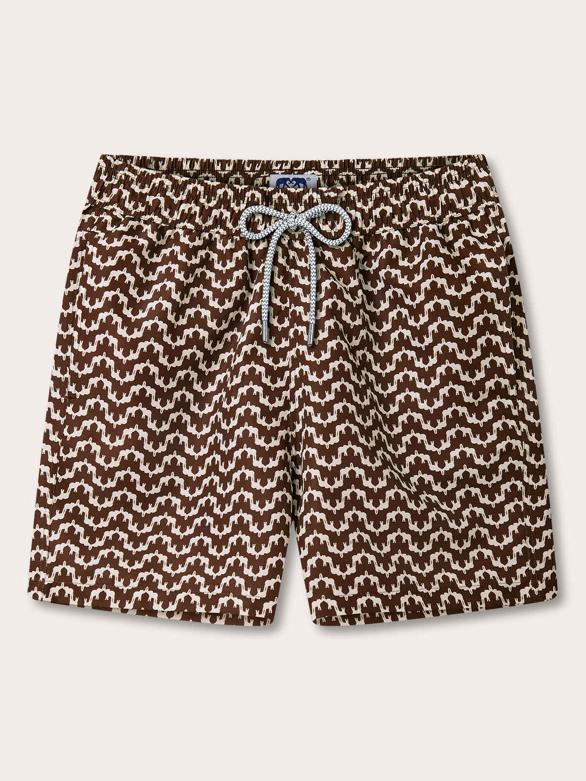 A pair of men's swim shorts featuring an all-over brown and off-white geometric pattern, with a matching patterned drawstring at the elastic waistband, shown flat on a light grey background.