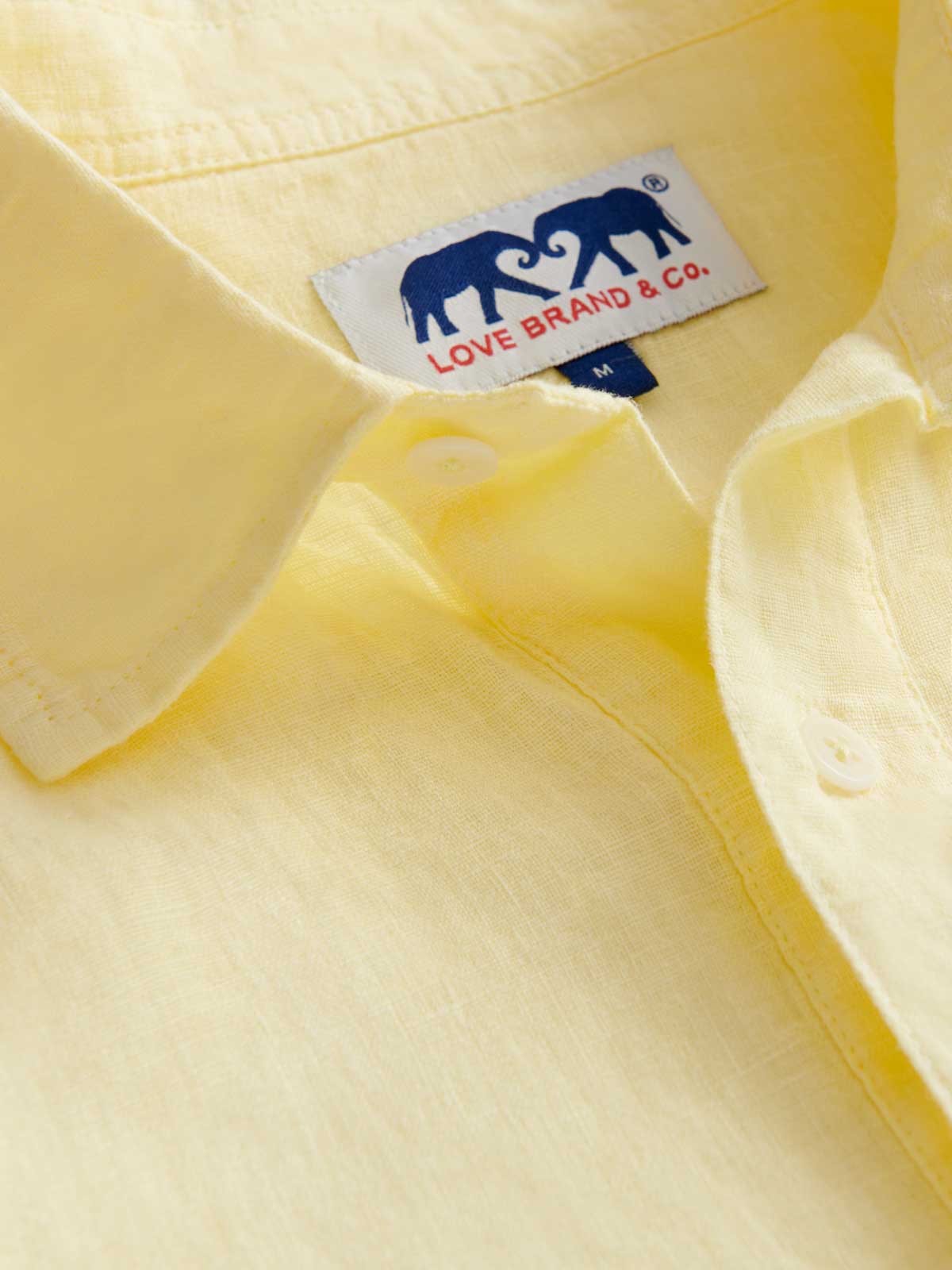 Close-up collar view of Men's Limoncello Hoffman Linen Shirt. Yellow linen half button up shirt with love brand label.