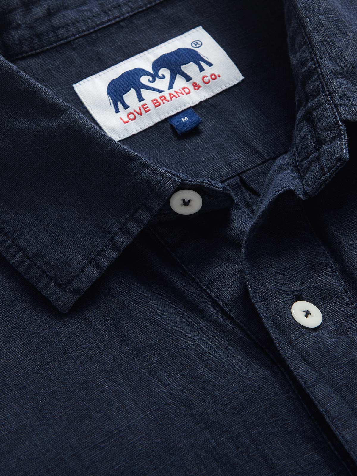 Close-up view of Men's Navy Blue Hoffman Linen Shirt. Navy blue linen shirt with long sleeves and half-button-up design.