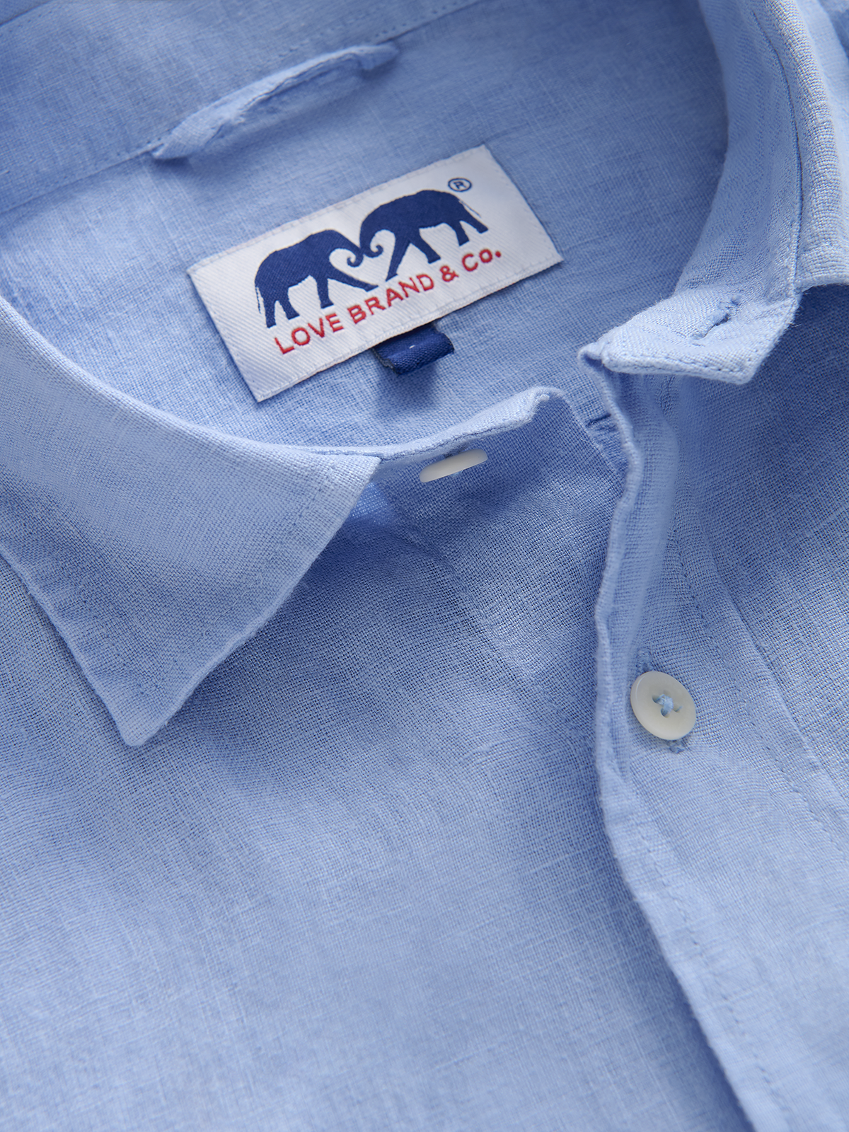 Close-up of a light blue shirt with a visible love brand label.