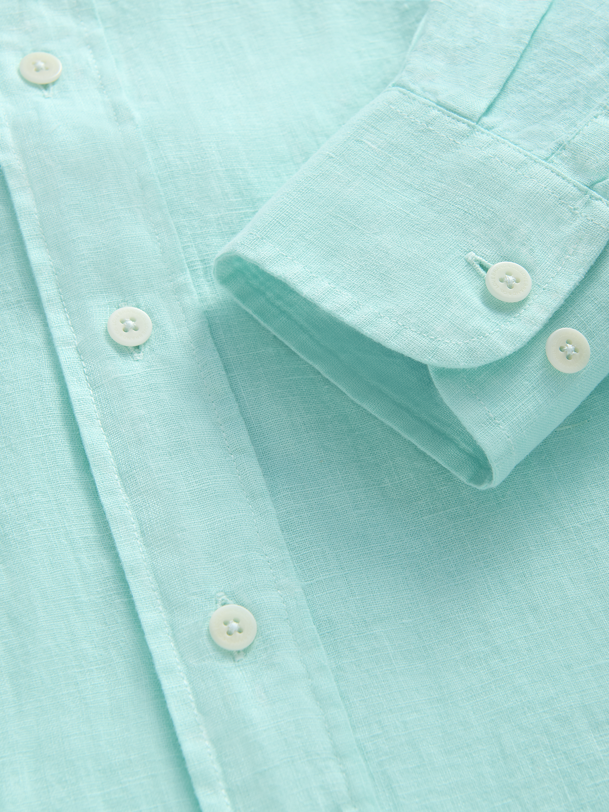 Close-up of a light green shirt with buttons