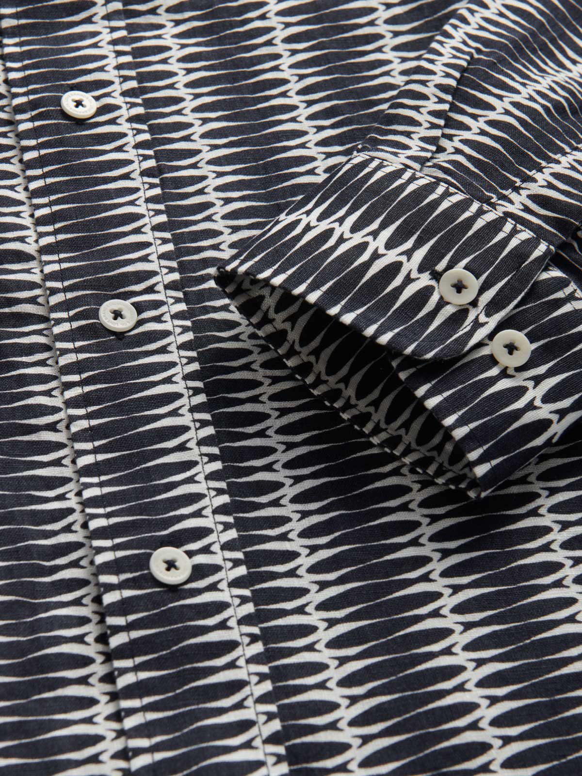 Close-up cuff view of men's silly sardines linen shirt.