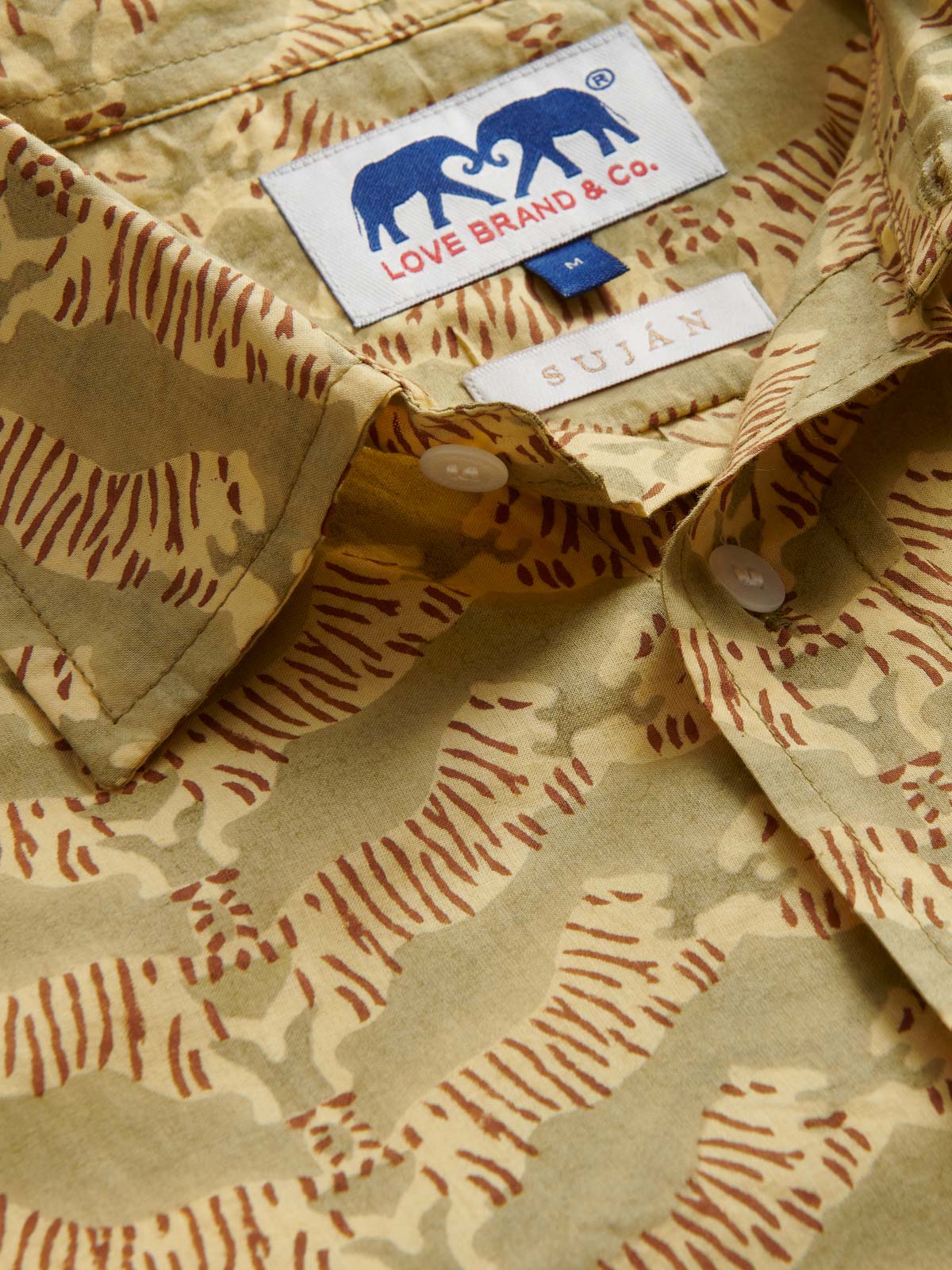 Close-up view of Men's Lurking Leopards Abaco Cotton Shirt collar. Showing SUJAN Camps logo and tiger print design.