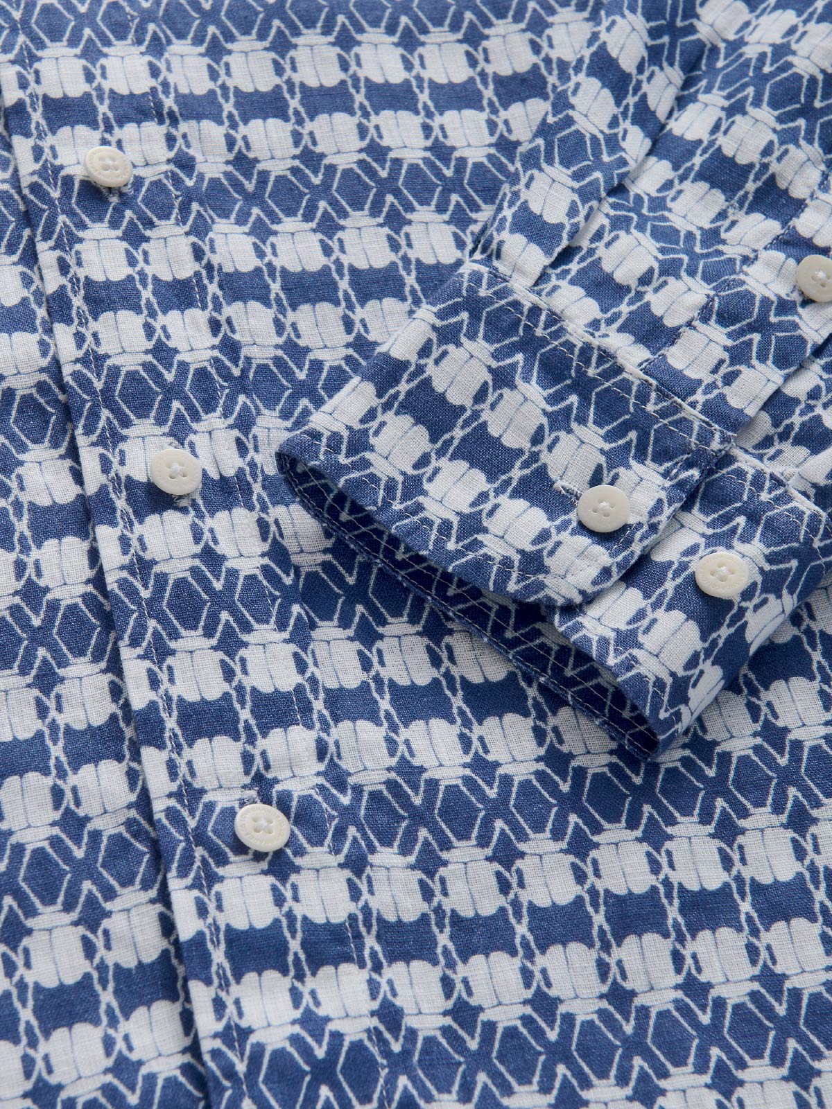 Close-up of a blue and white patterned fabric with buttons.