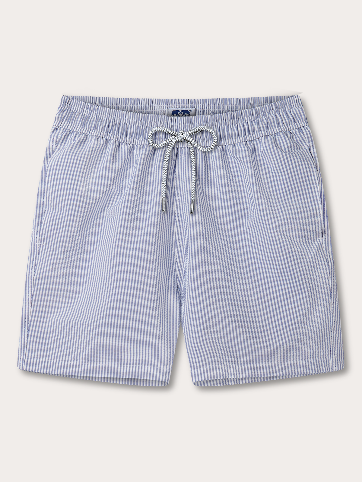 Light blue and white vertically striped swim trunks with an elastic waistband and a knotted drawstring, shown flat on a light beige background.