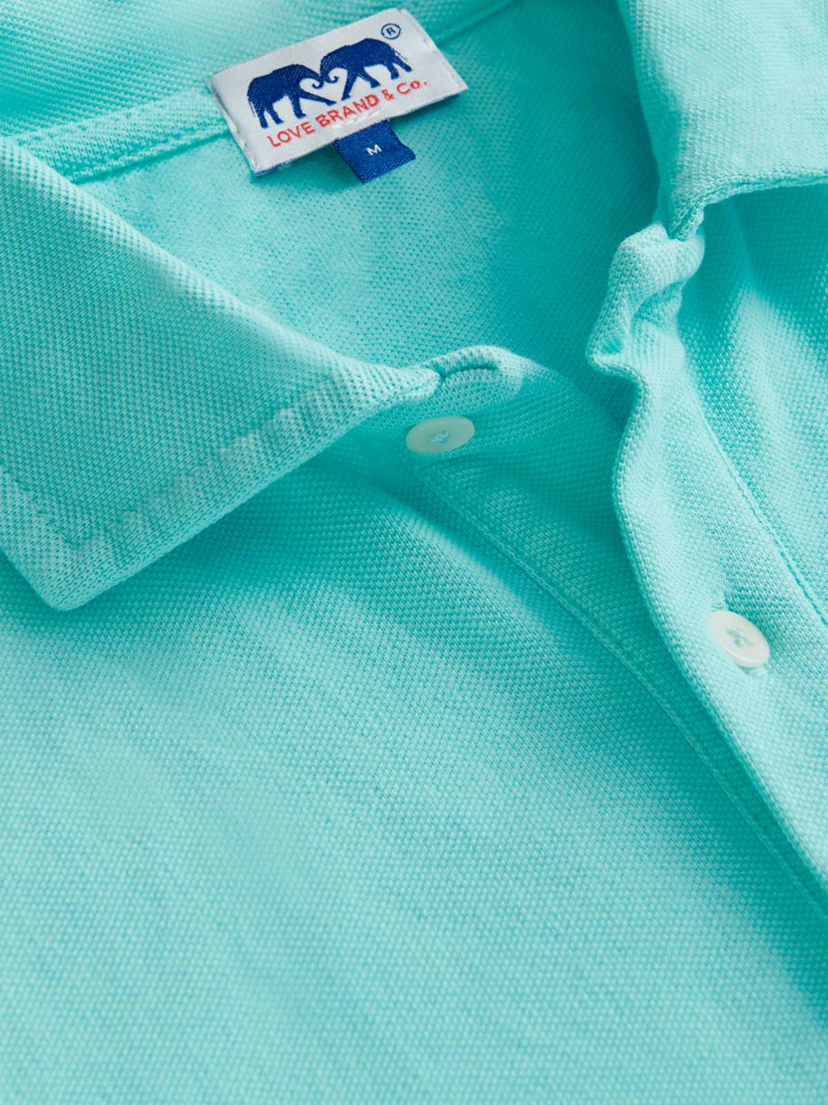 Close-up view of men's green polo shirt by love brand.