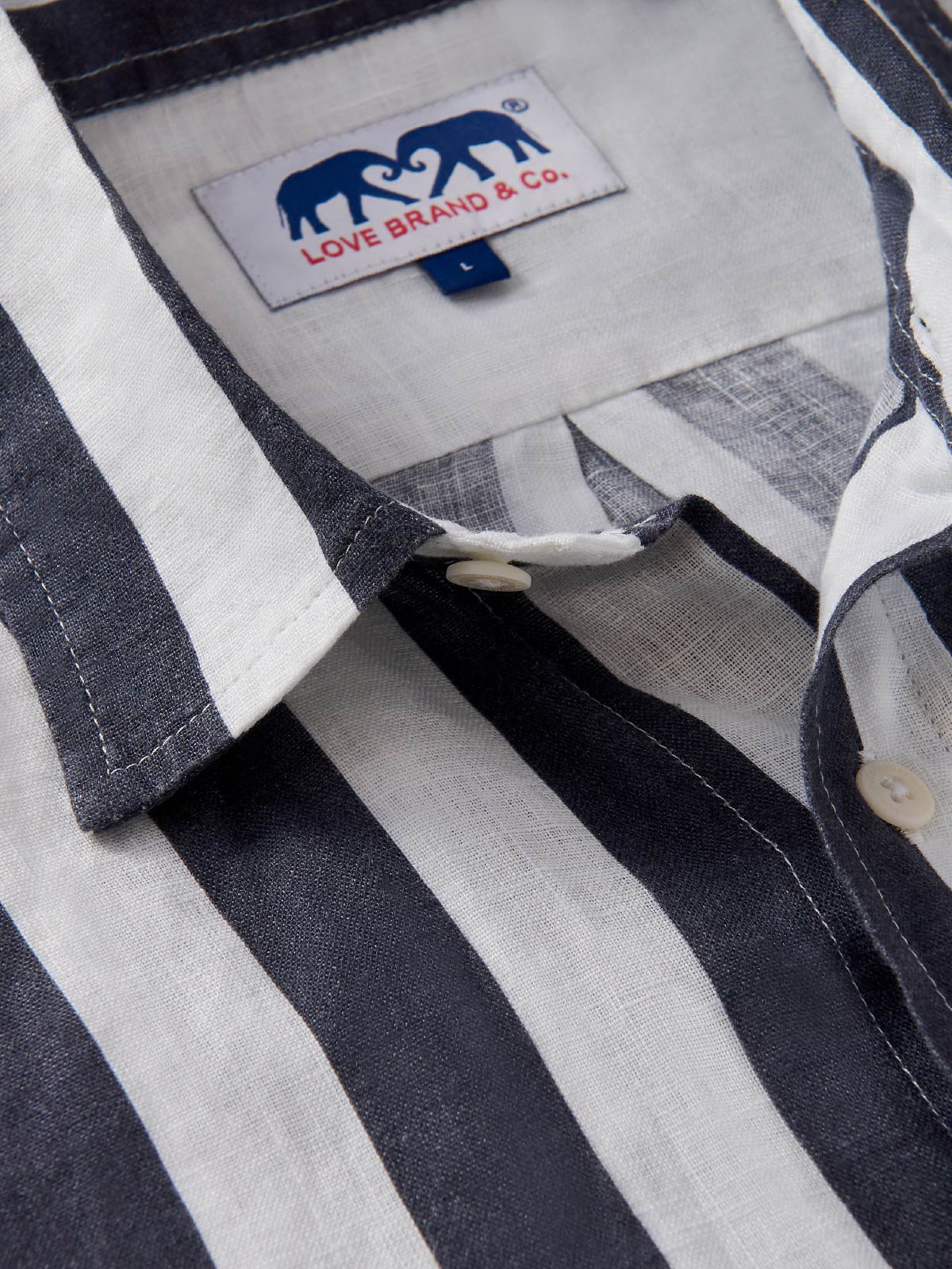 Close-up of a striped shirt with a visible love brand label on the collar.