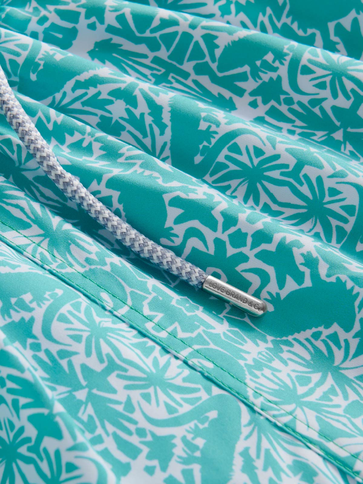Close-up of a teal and white patterned swimming shorts fabric