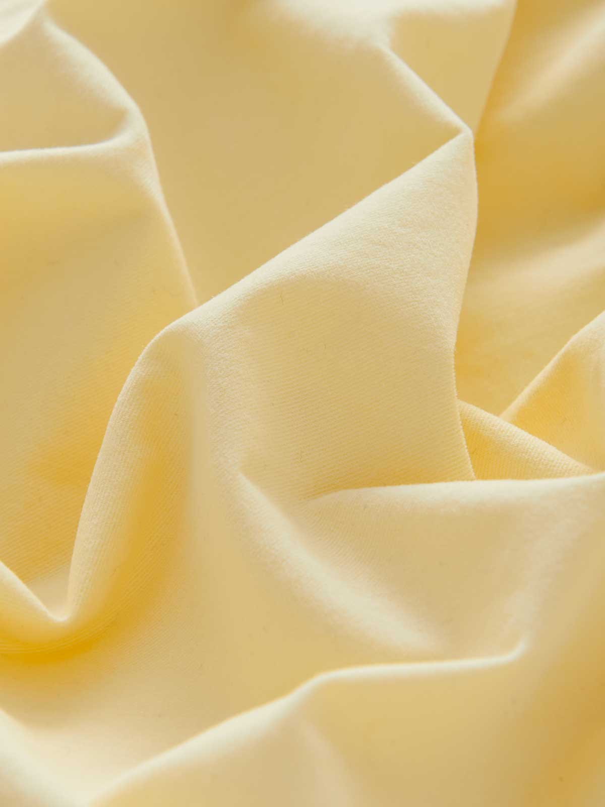 Close-up fabric view of men's yellow cotton shorts by love brand.