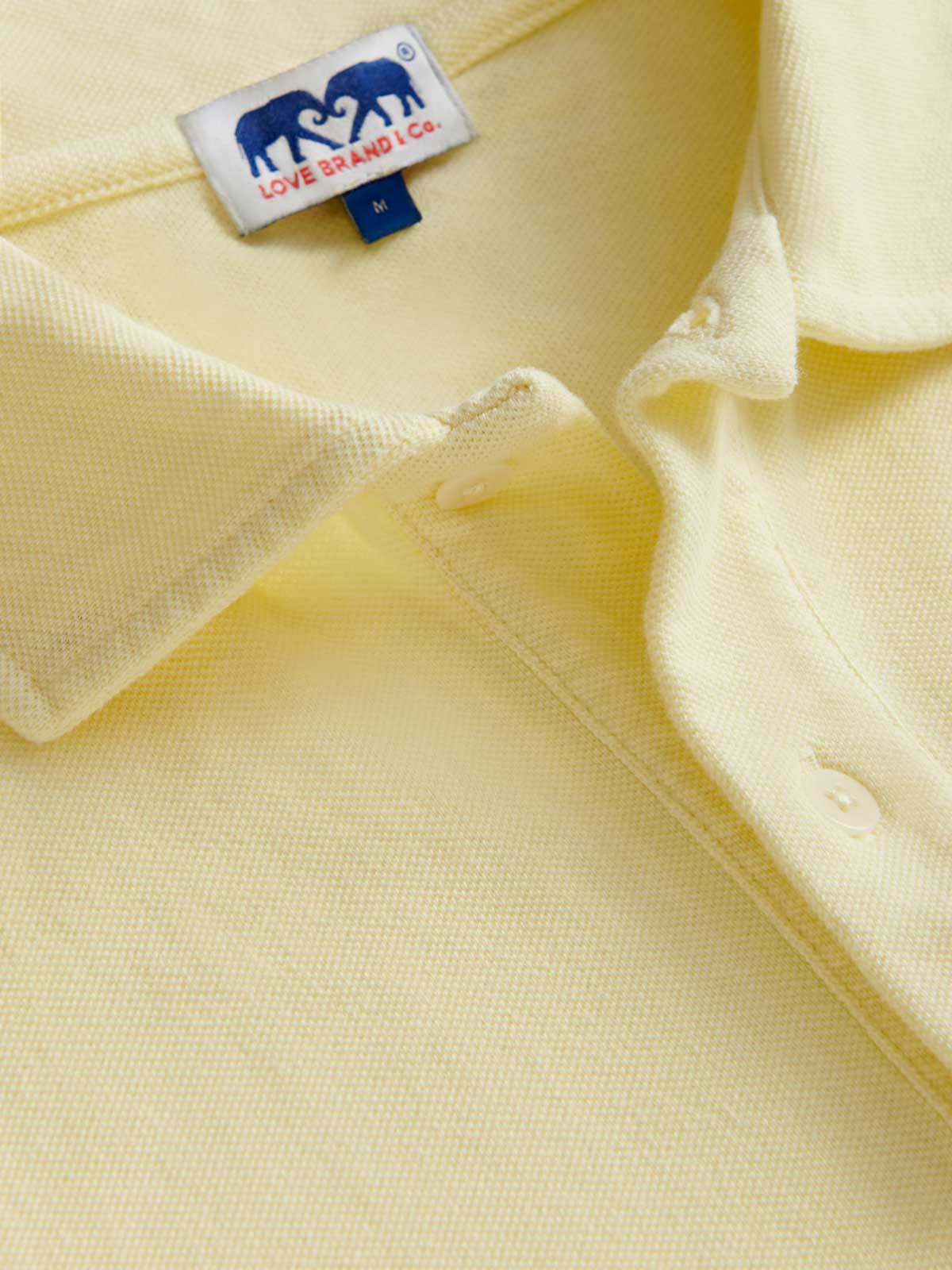detailed view of Men's Limoncello Pensacola Polo Shirt. Yellow polo shirt with white buttons.
