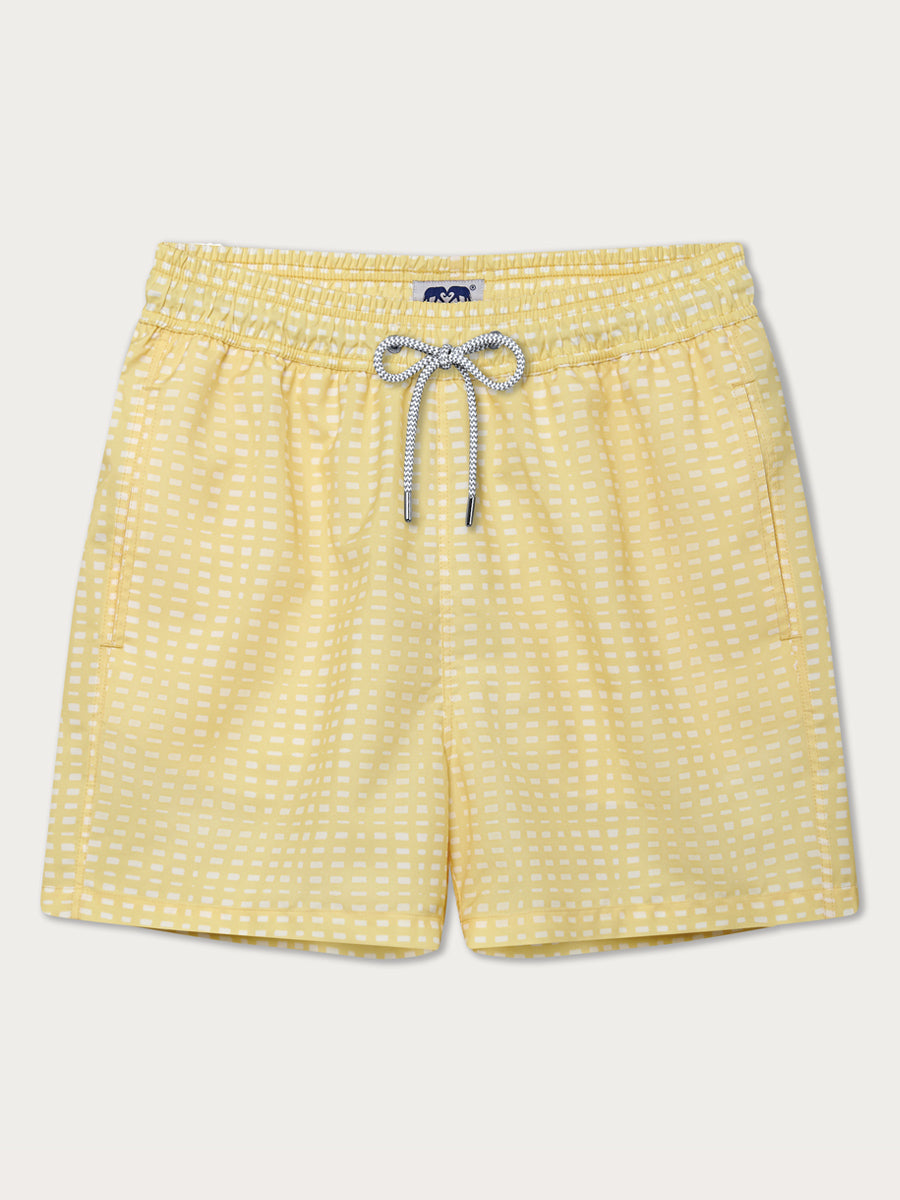 Men's yellow Staniel Swim Shorts with white square pattern, inspired by yellow-strapped pool deckchairs, featuring an elastic waistband with a drawstring, made from 100% recycled quick-dry fabric for comfort and style.