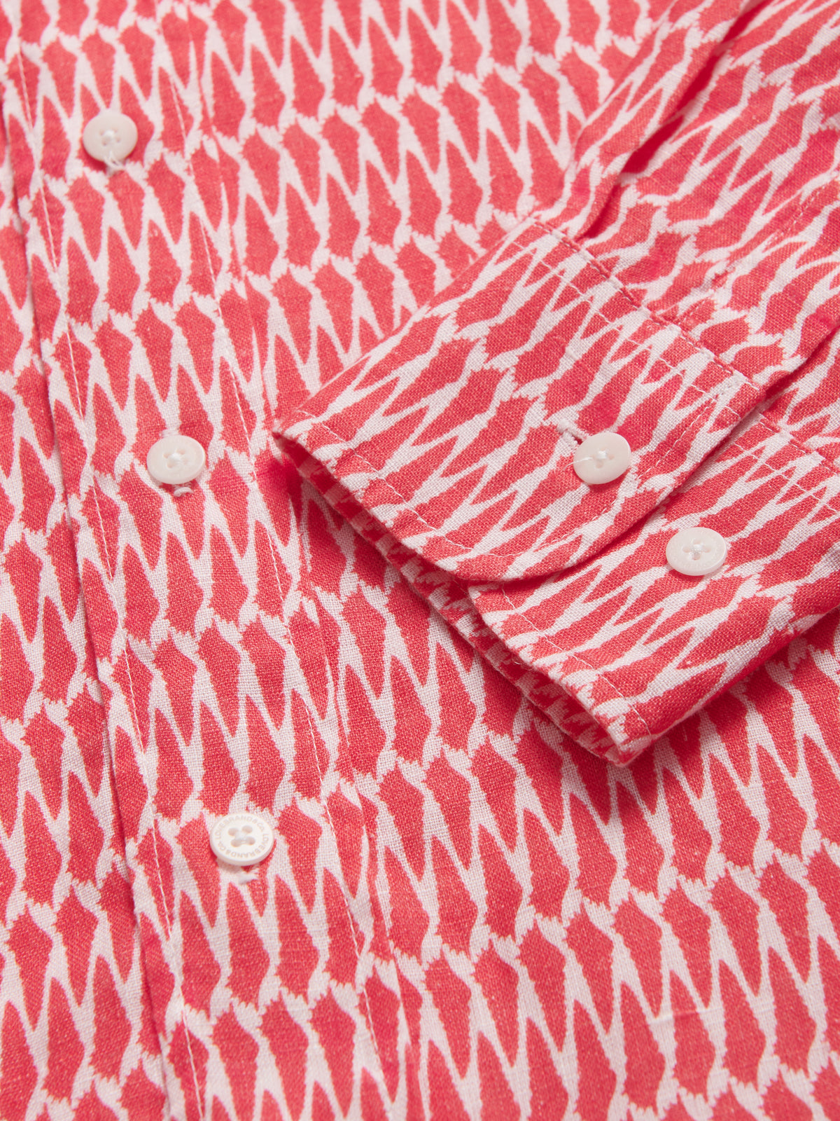 Close-up view of Men's Hot as Shell Abaco Linen Shirt cuffs. Red and white linen button up shirt.