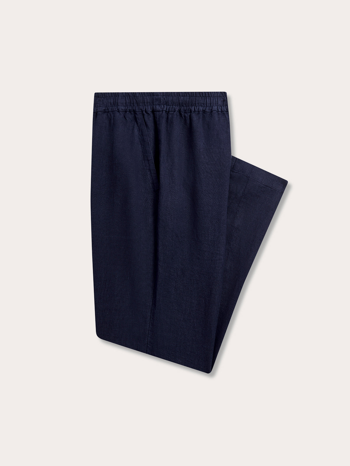 Folded view of Men's Navy Blue Eleuthera Linen Trousers. Navy blue linen pants for men with 2 front pockets and drawstring waist in a relaxed fit.