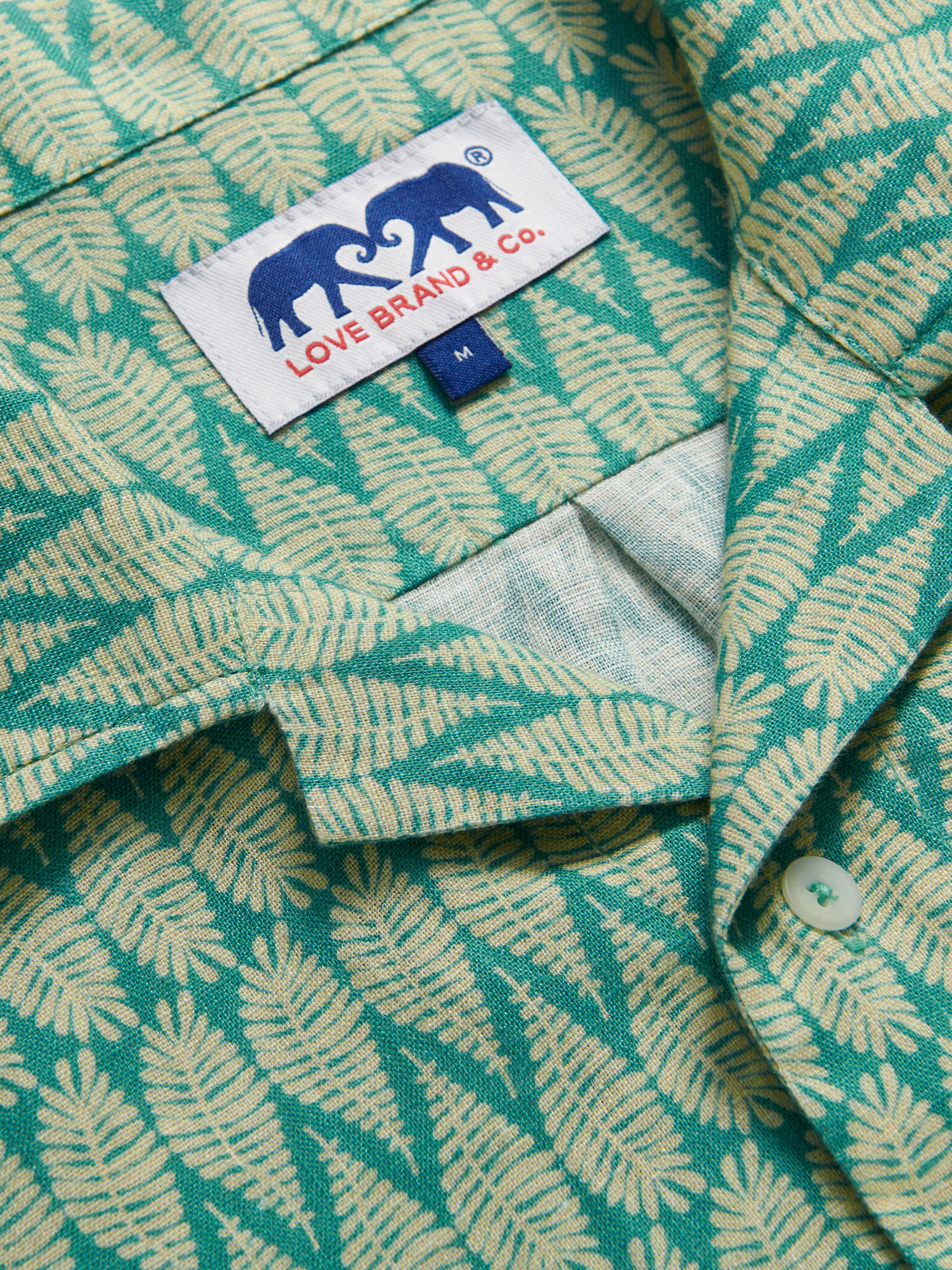 Detailed view of Men's Paradise Arawak Linen Shirt. Close-up view of the collar of this men's green shirt.