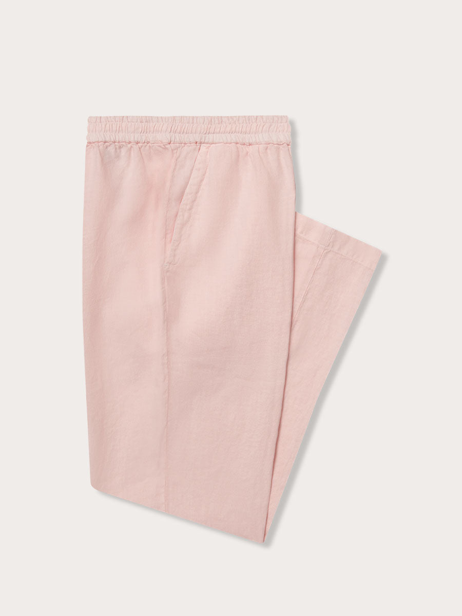 Men's pastel pink Eleuthera linen trousers neatly folded. Linen clothing for men with pockets.