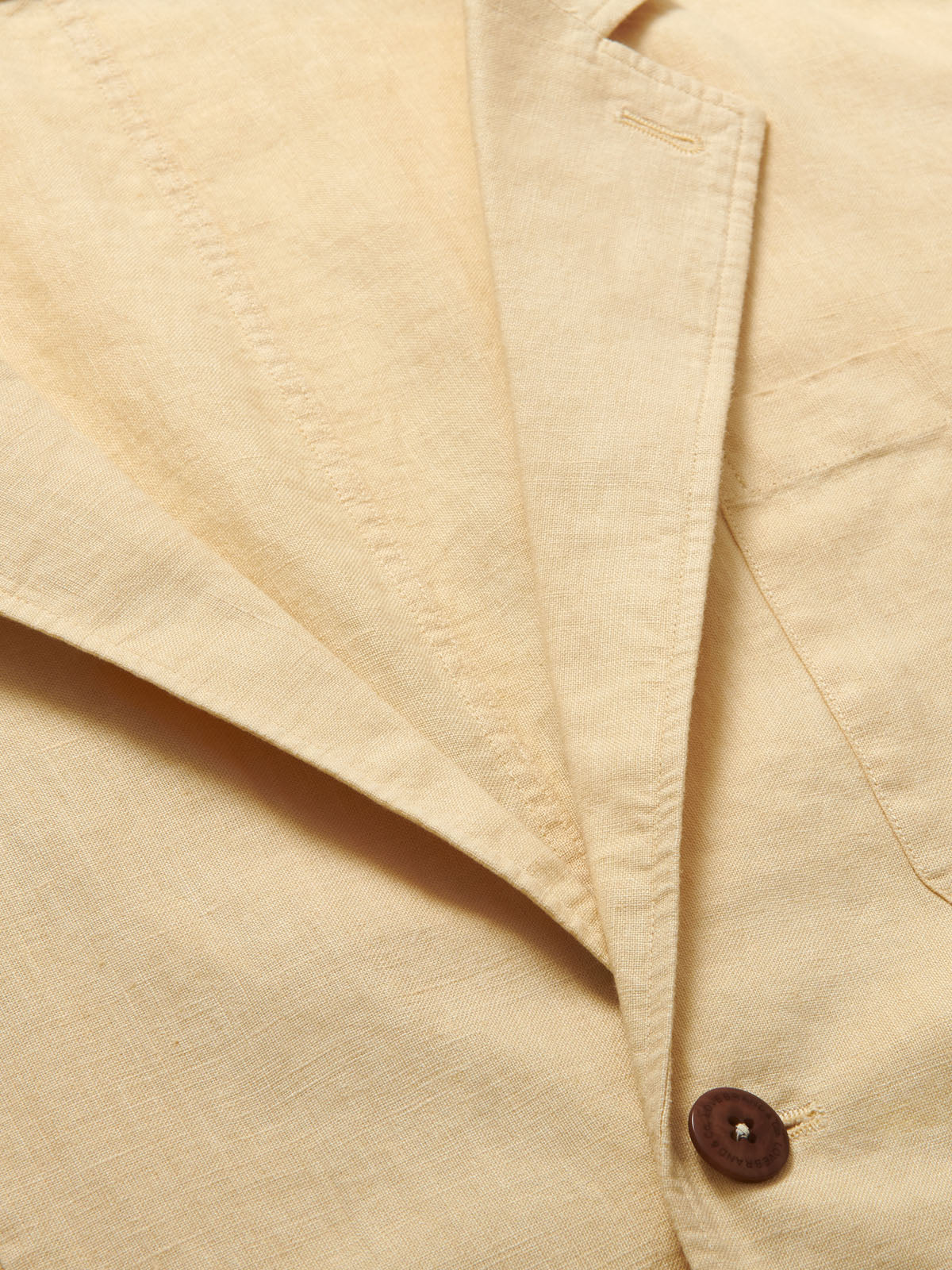 Close-up view of the Men's Stone Nassau Linen Jacket showcasing its light linen fabric and corozo nut button.