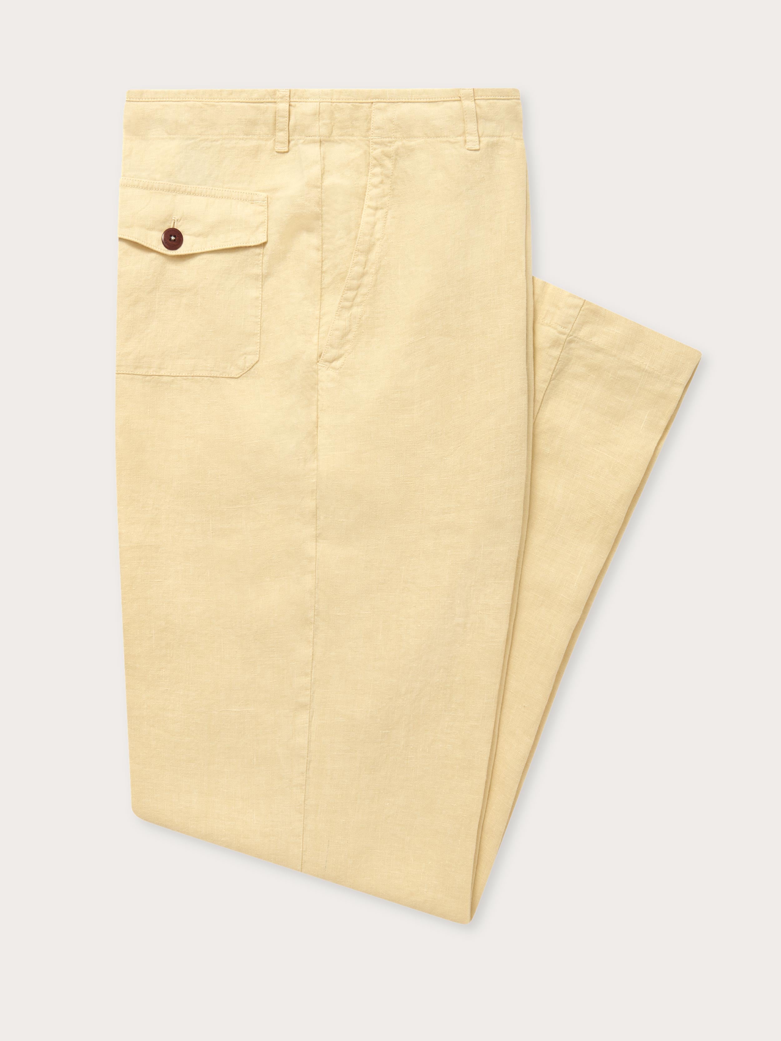 Mens linen trousers folded neatly on a flat surface, showcasing their natural stone color and cooling fabric. Perfect for old money styling.