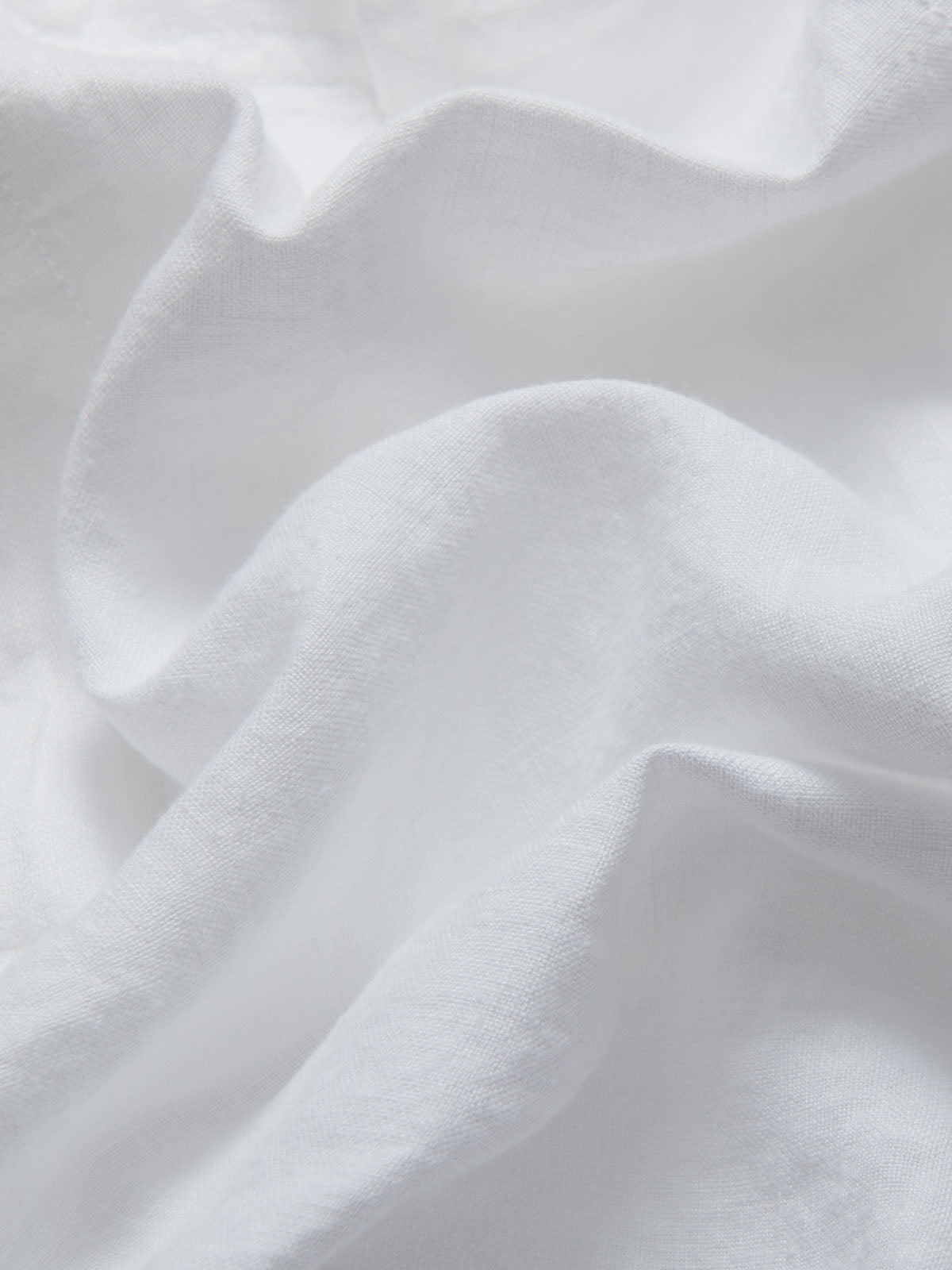 Detailed view of the white 100% linen fabric of mens linen white shorts by Love Brand.