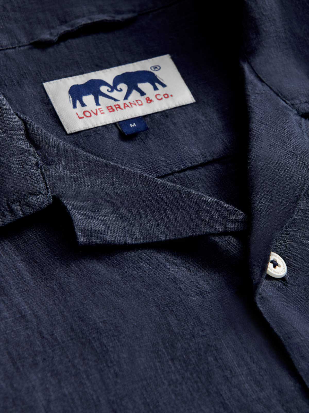 Close-up of Men's Navy Blue Arawak Linen Shirt. Camp collar view of love brand's navy blue linen shirt.