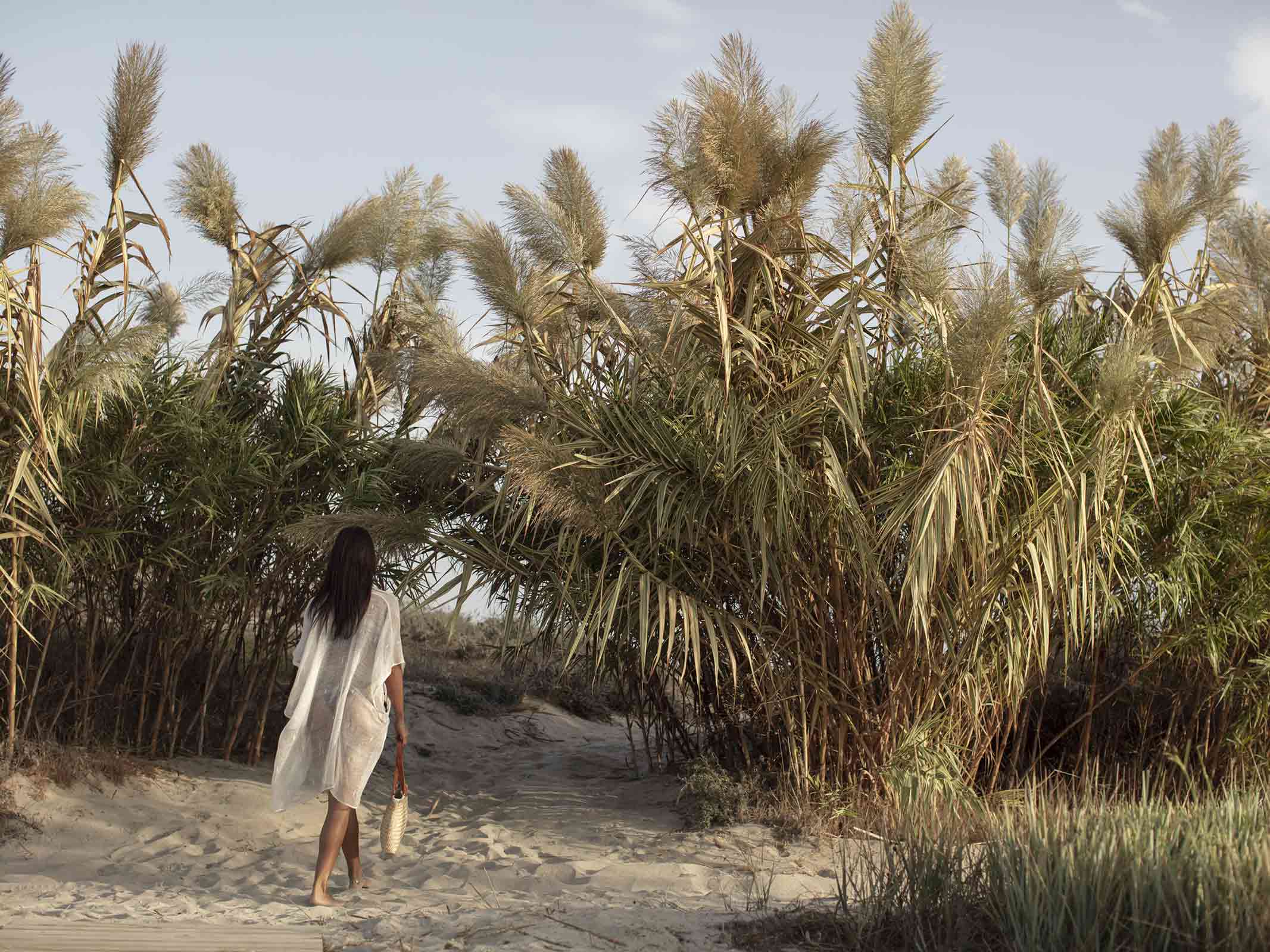 Woman walks along the private beach at OKU Kos hotel