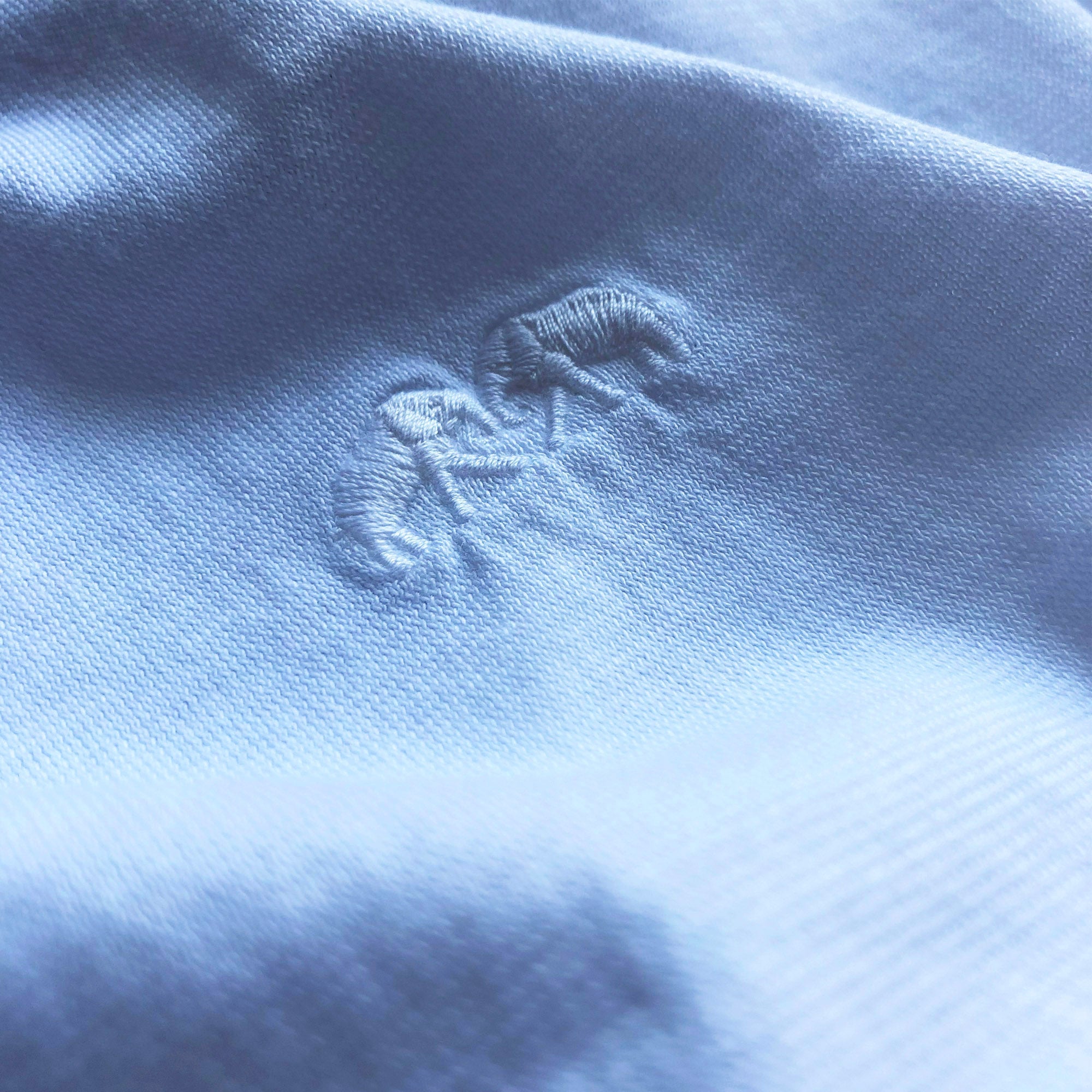 Close-up view of the Men's Ocean Blue Lockhart T Shirt fabric texture, showcasing the intricate weave and sophisticated calm blue color.