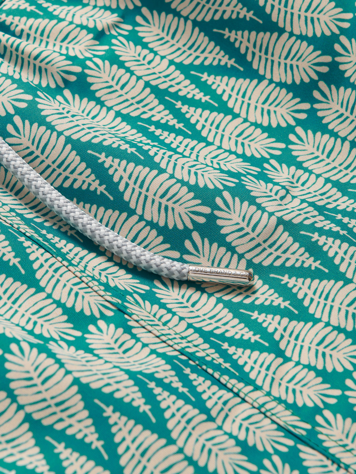 Close-up view of Paradise Staniel Swim Shorts. Designer swimwear with drawstring waist and leaf pattern.