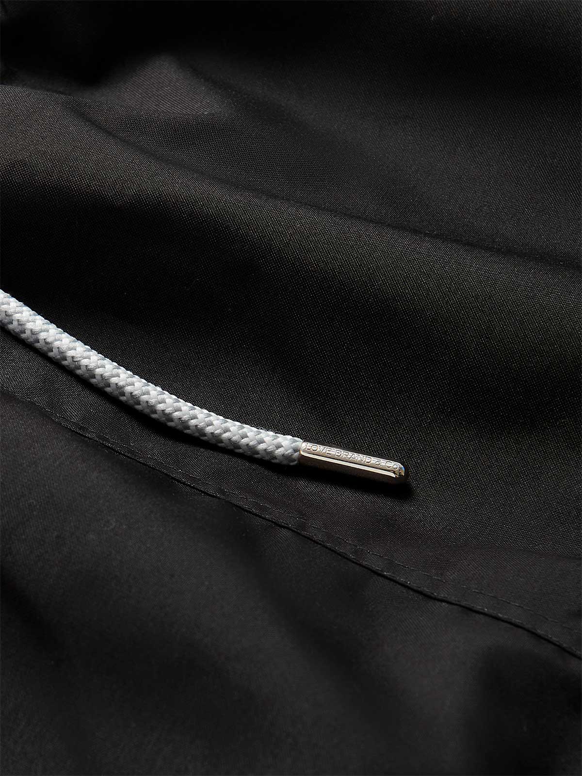 Close-up view of the black swim short showing detailed texture and drawstring.